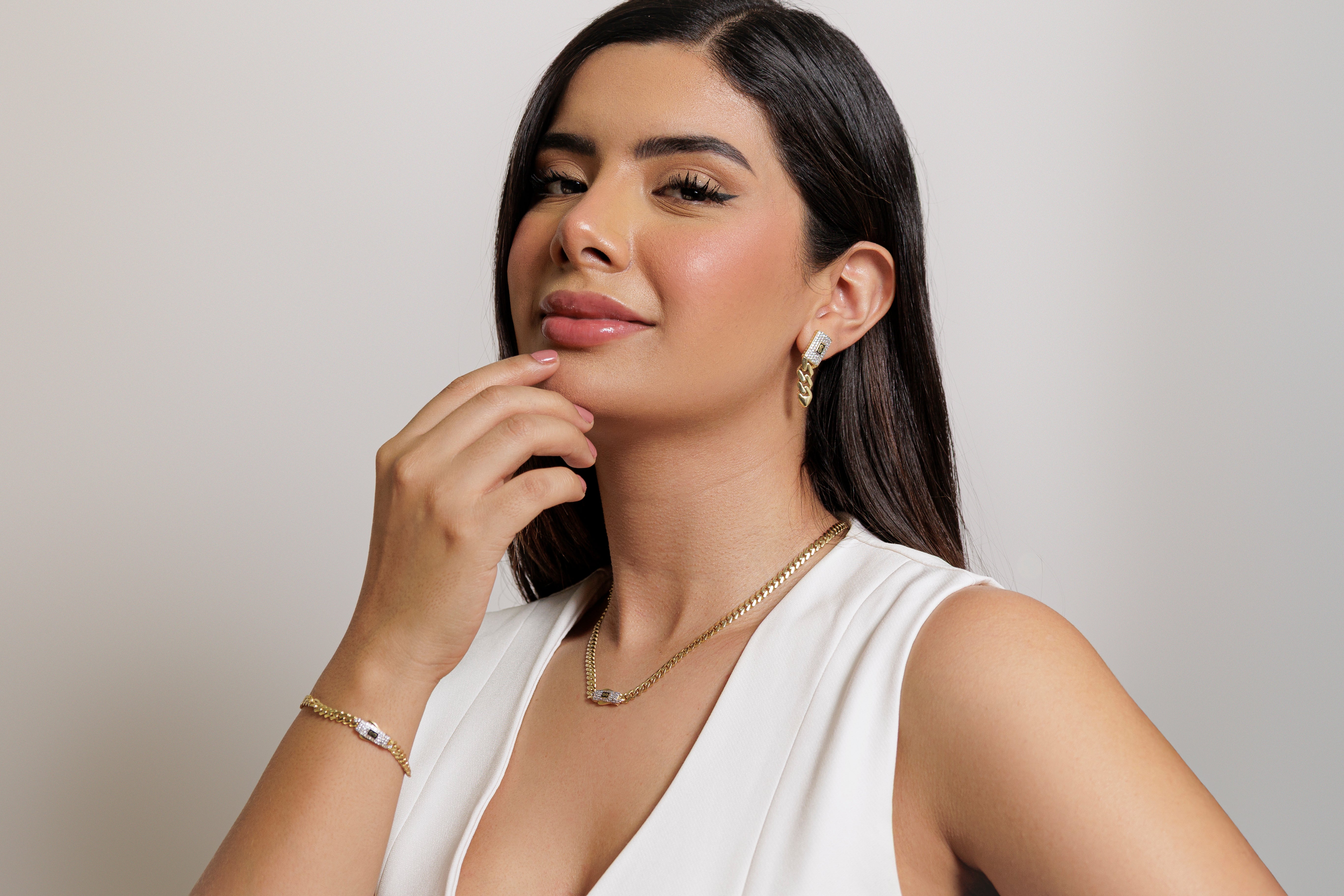 Mujer luciendo elegantes joyas en oro de la colección Línea Monaco Chain, incluyendo aretes, collar y pulsera, perfectos para regalar este Día de la Madre 2025.