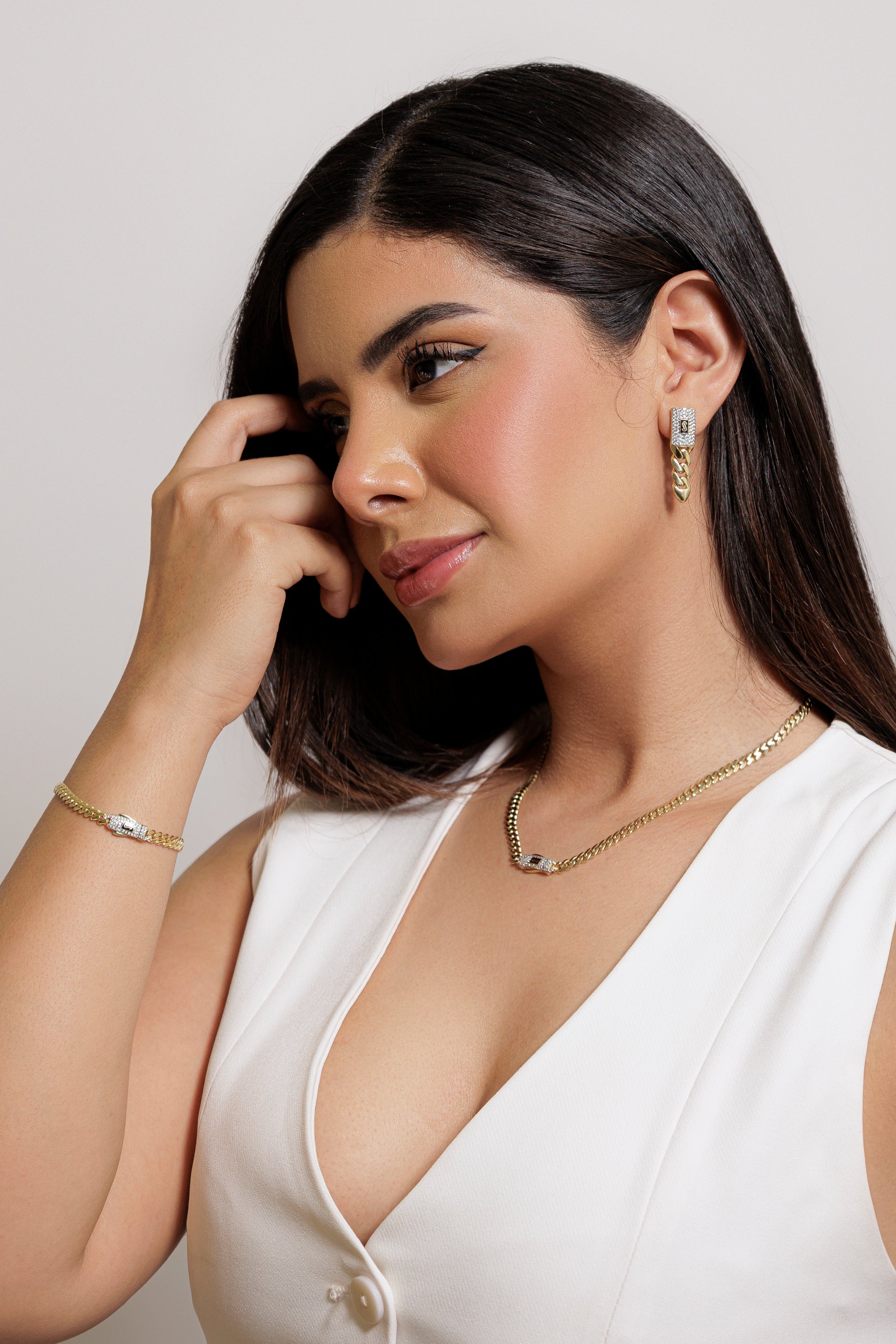 Mujer usando aretes de oro con diseño elegante, ideal para uso diario o eventos especiales.